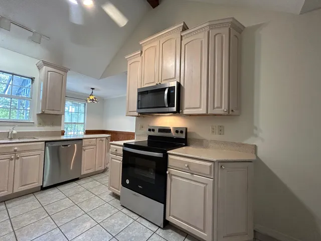 a kitchen with granite countertop cabinets stainless steel appliances and a sink