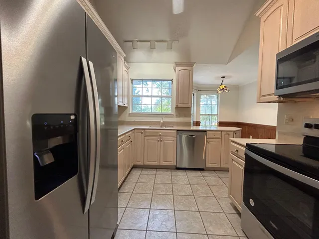 a kitchen with stainless steel appliances a refrigerator sink and microwave