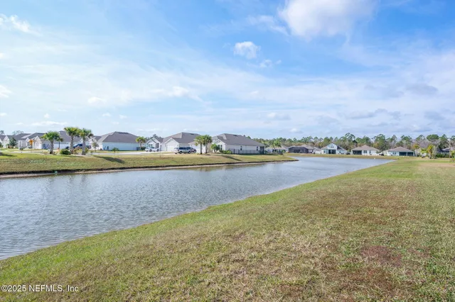 a front view of a house with a garden and lake view