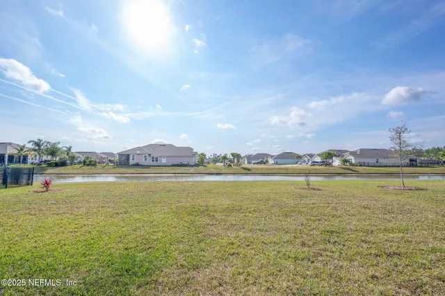 a front view of a house with a yard and potted plants