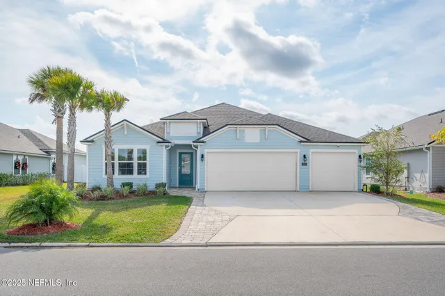 a front view of a house with a garden and trees