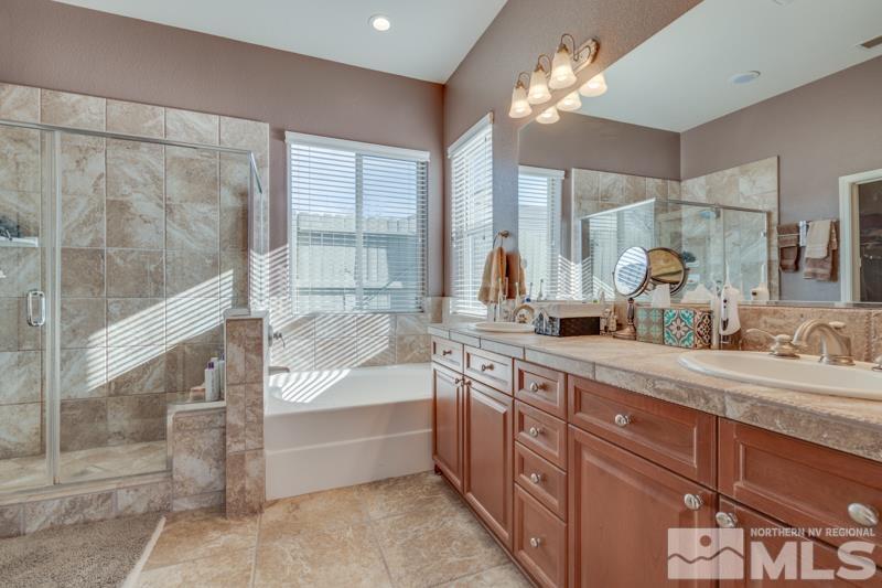 1696 Ghettis Way Reno, NV 89521 - Photo 17 of 25 a spacious bathroom with a granite countertop tub sink a mirror and shower