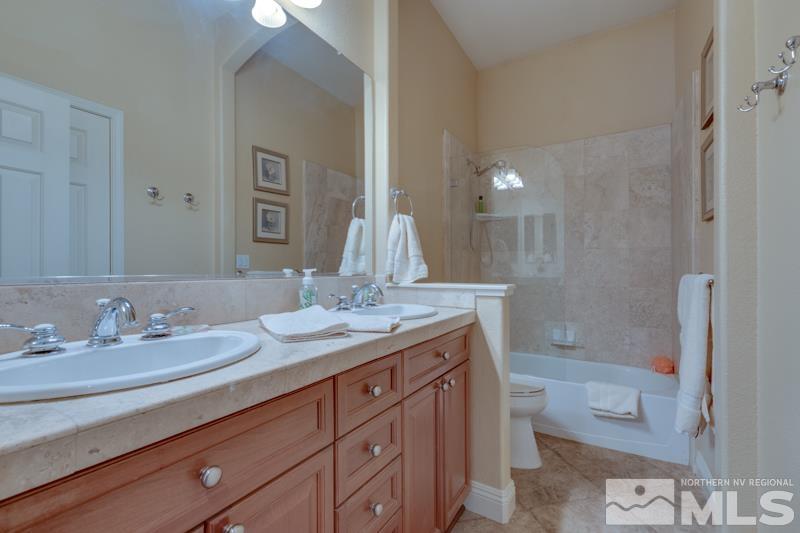 1696 Ghettis Way Reno, NV 89521 - Photo 20 of 25 a bathroom with a granite countertop sink and a mirror