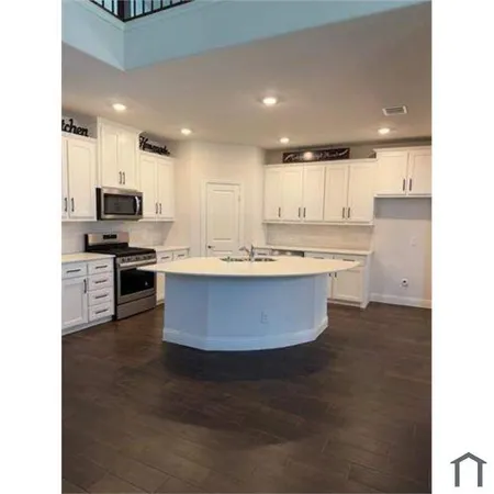 a large kitchen with stainless steel appliances kitchen island granite countertop a stove a sink a refrigerator and a cabinets