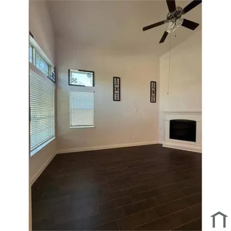 a view of a livingroom with wooden floor and a ceiling fan