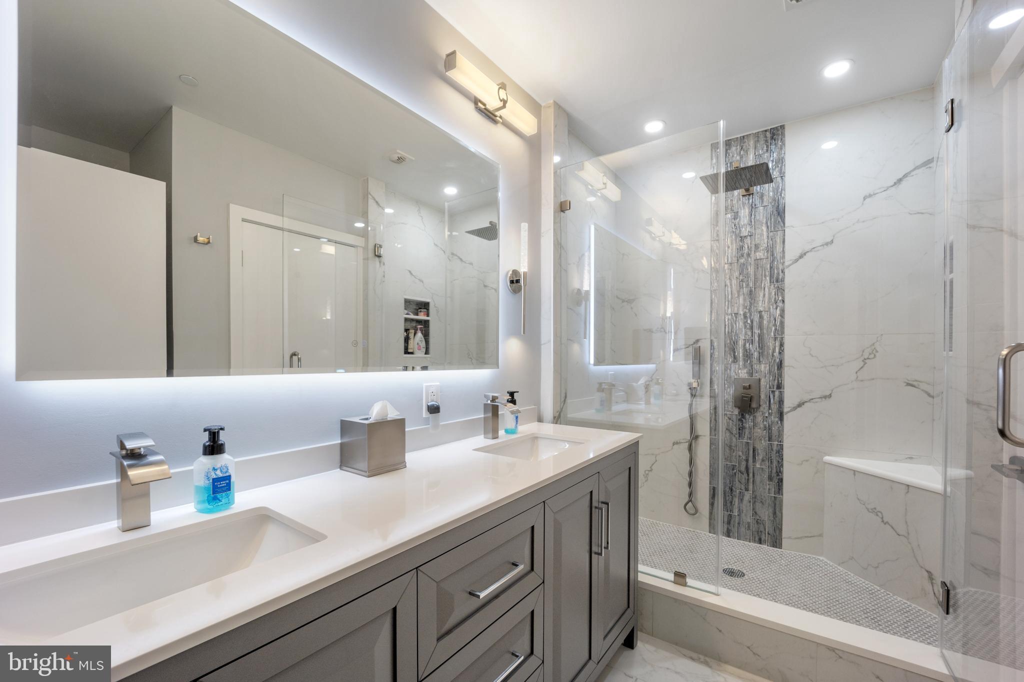 a bathroom with a double vanity sink mirror double and shower