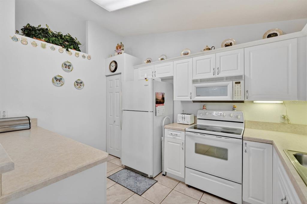 80 Roxboro Drive Palm Coast, FL 32164 - Photo 13 of 39 a kitchen with white cabinets and white appliances