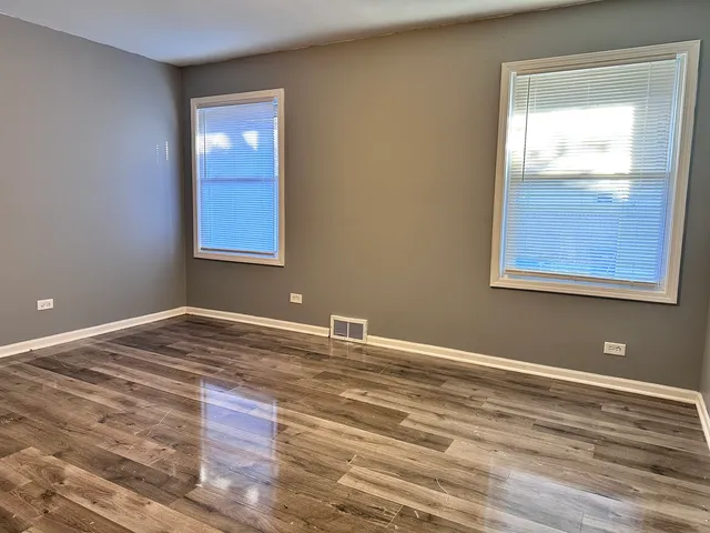 a view of a room with wooden floor and windows