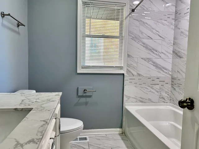 a bathroom with a sink a toilet and bathtub