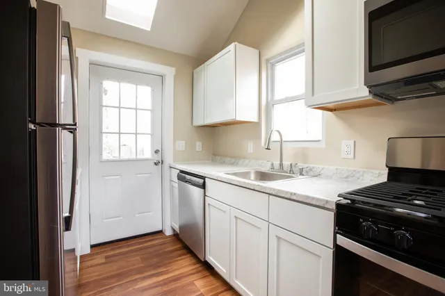 a kitchen with a sink stove top oven and cabinets