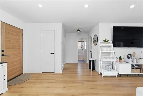 a view of a livingroom with wooden floor and a flat screen tv