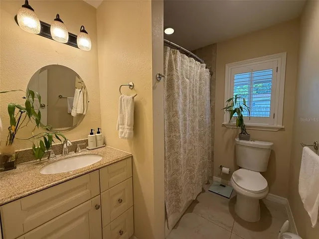 a bathroom with a toilet a sink and a mirror