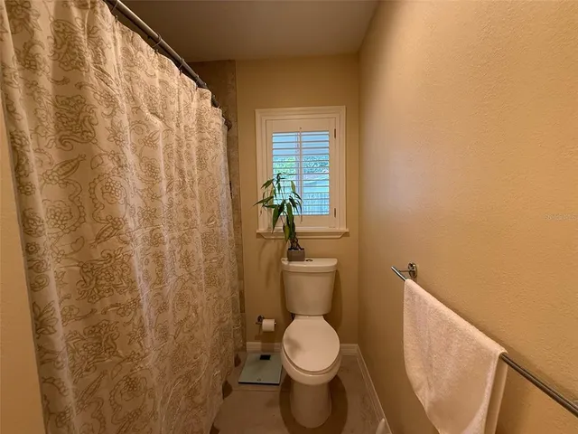 a bathroom with a toilet and a shower curtain