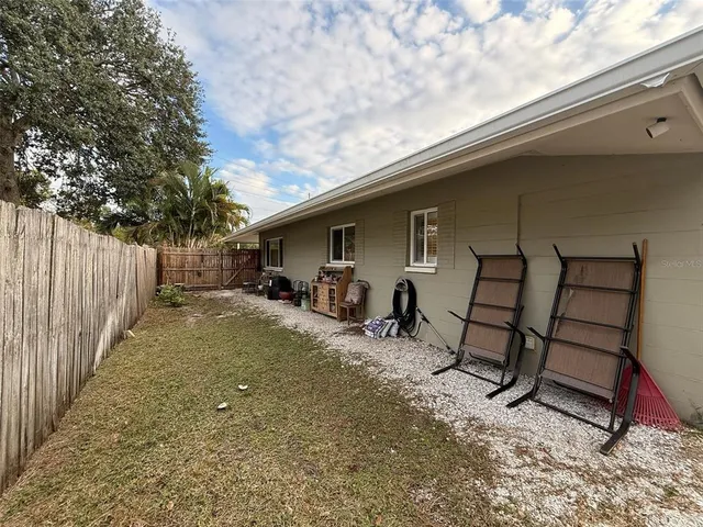 a view of backyard with a table and chairs and wooden fence
