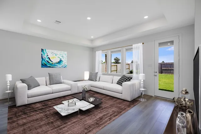 a living room with furniture and a wooden floor