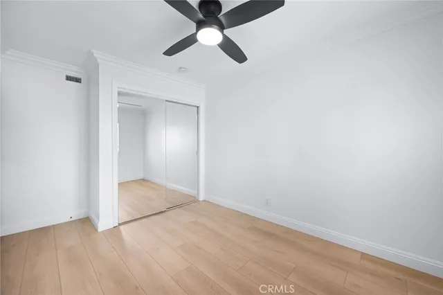 an empty room with a ceiling fan and carpet