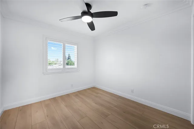 an empty room with a window and a ceiling fan