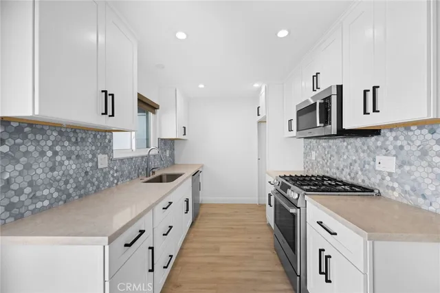 a kitchen with stainless steel appliances granite countertop a stove a sink and a microwave