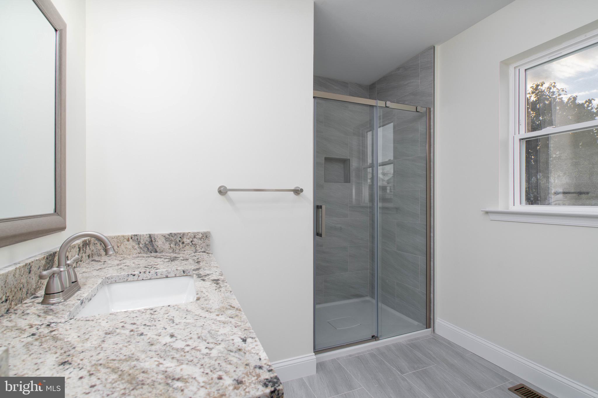 308 Gray Street Townsend, DE 19734 - Photo 23 of 33 a bathroom with a granite countertop sink a mirror and shower