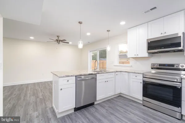 a kitchen with stainless steel appliances granite countertop a stove a sink and a microwave