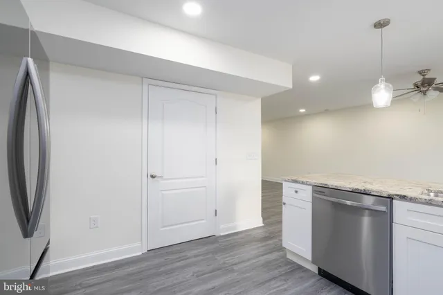 a view of a kitchen with a sink and dishwasher with wooden floor