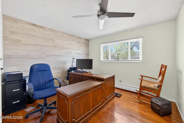 a view of a workspace with furniture and a window