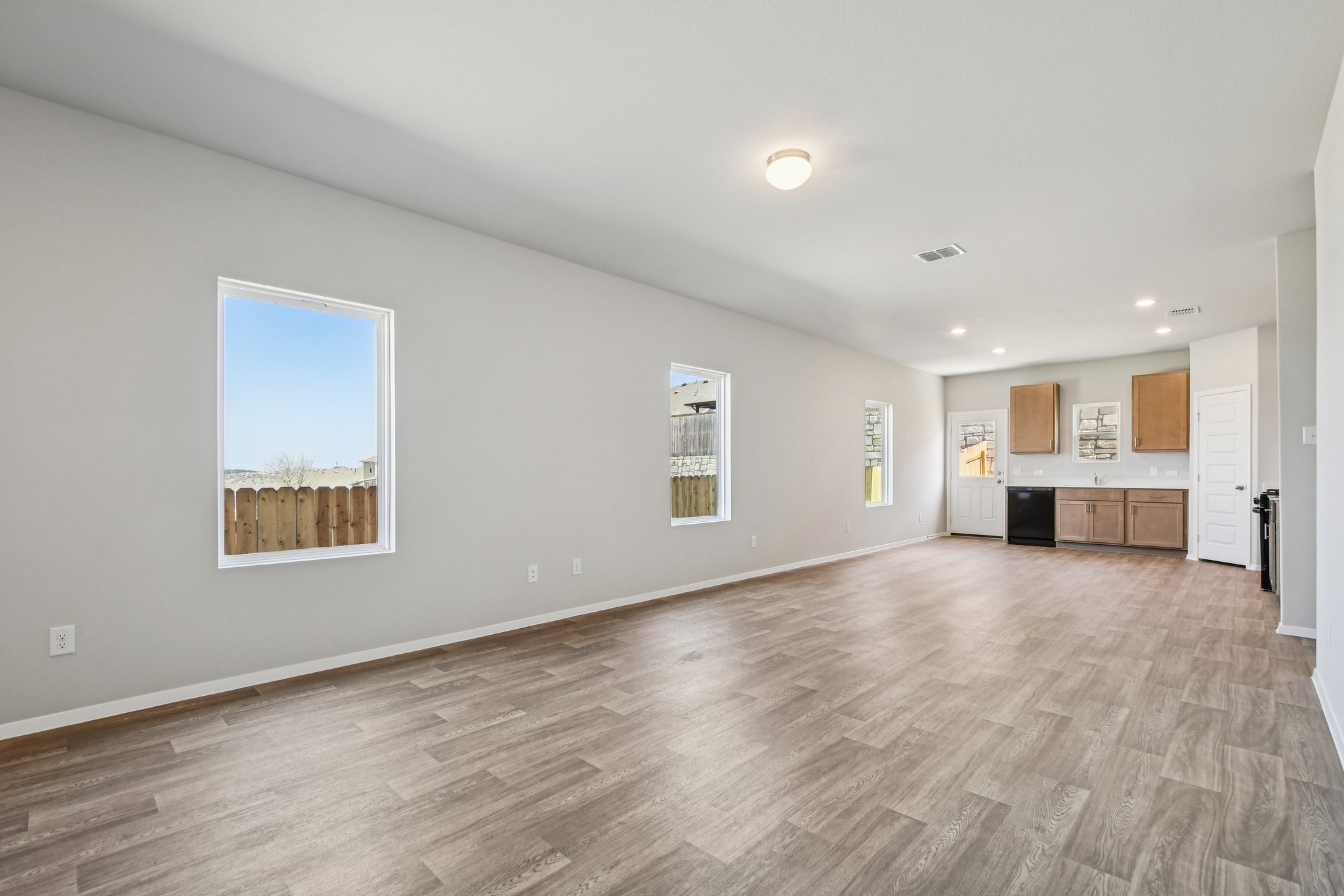 11913 Ellena Cove Austin, TX 78747 - Photo 12 of 35 a view of kitchen and hall with wooden floor and windows