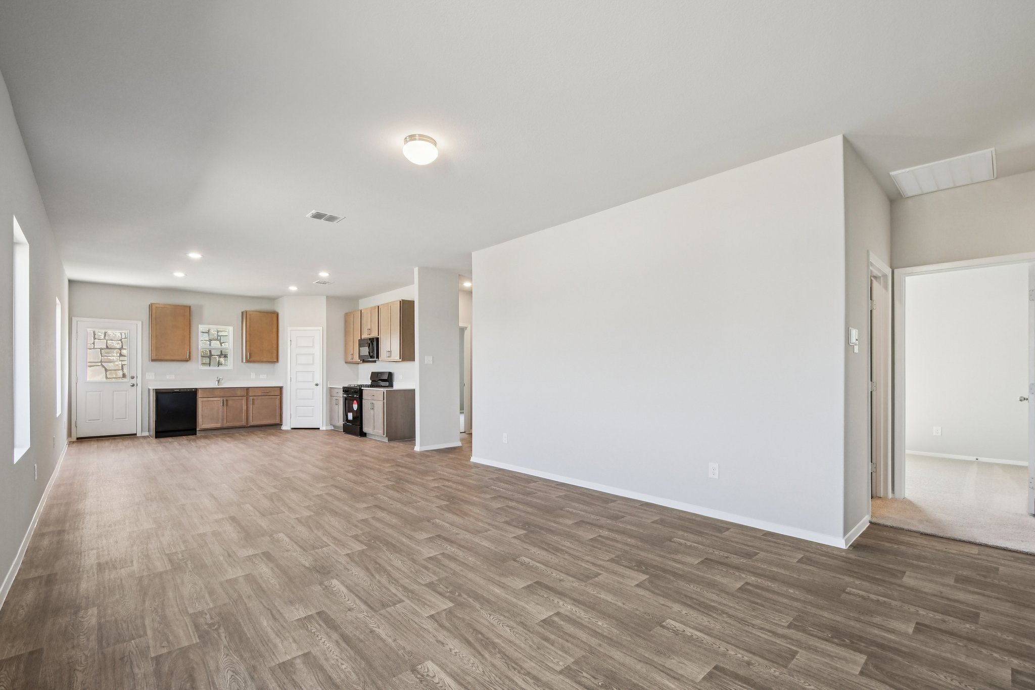 11913 Ellena Cove Austin, TX 78747 - Photo 13 of 35 a view of a room with wooden floor and a kitchen