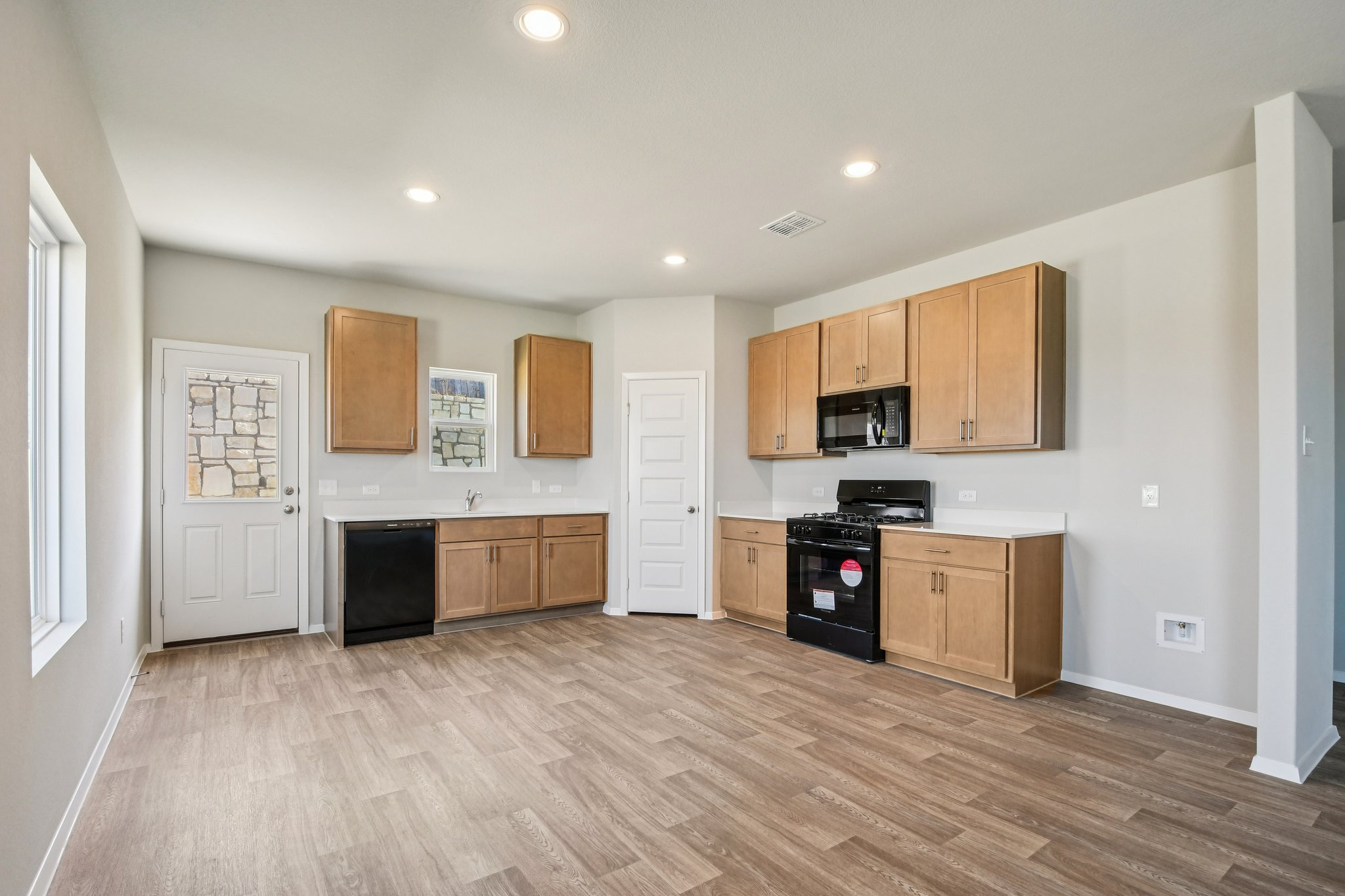 11913 Ellena Cove Austin, TX 78747 - Photo 6 of 35 a large kitchen with stainless steel appliances granite countertop a stove and a wooden floors