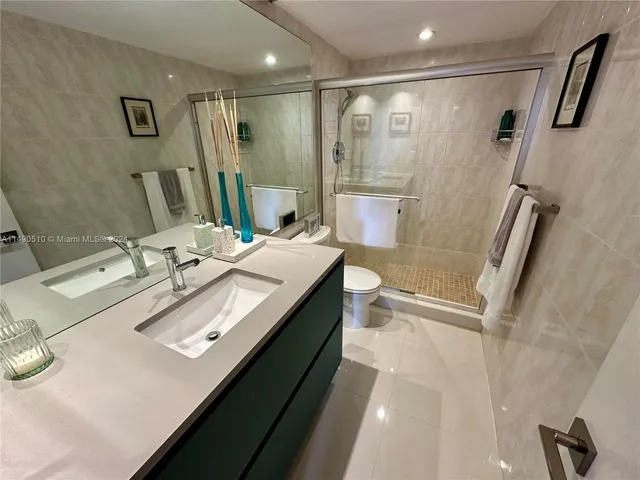 a bathroom with double vanity sink a mirror and a shower