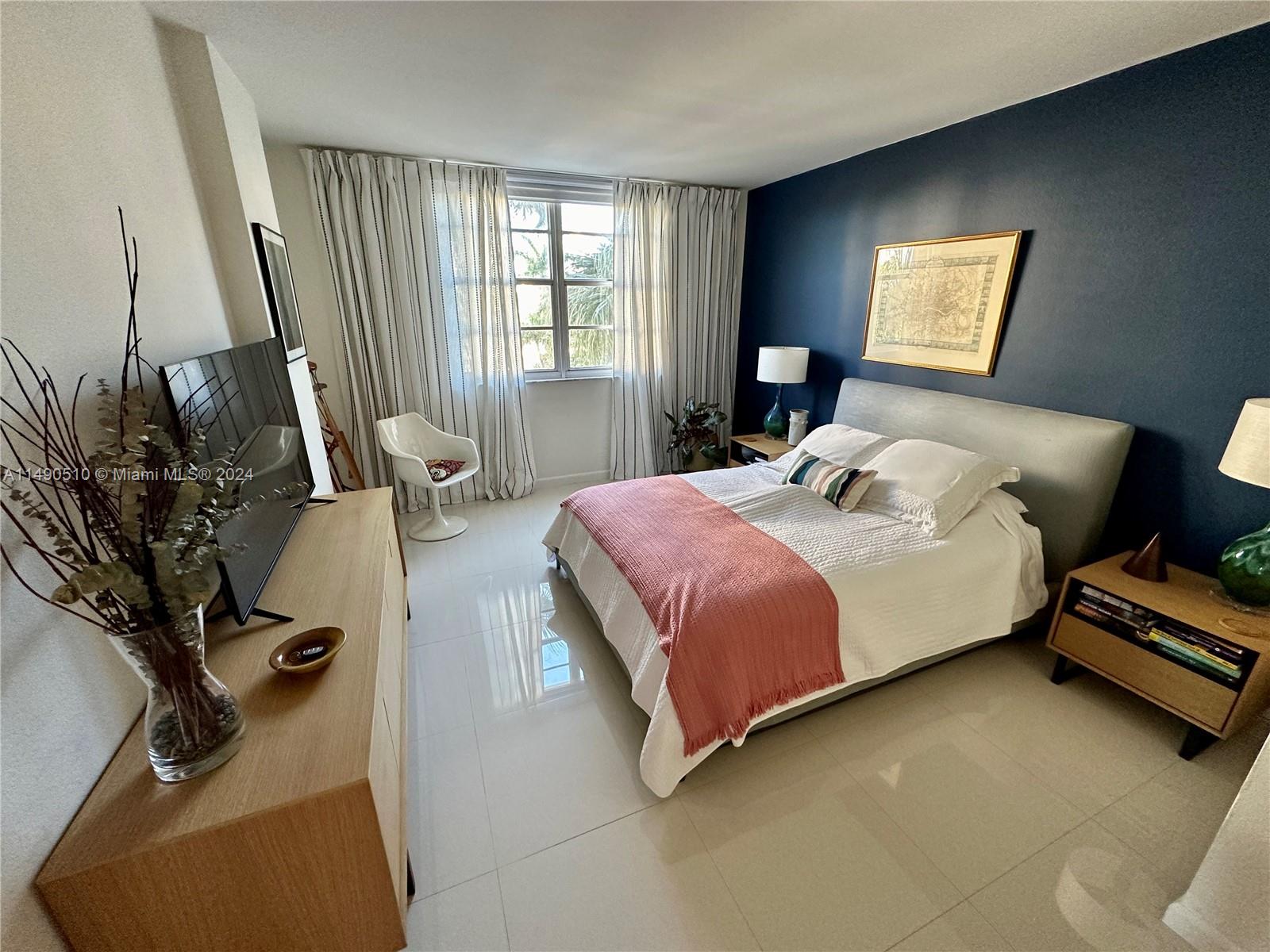 500 Bayview Drive, Unit 221 Sunny Isles Beach, FL 33160 - Photo 16 of 35 a bedroom with a bed and wooden floor