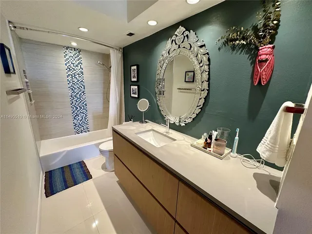 a bathroom with a sink mirror and a shower