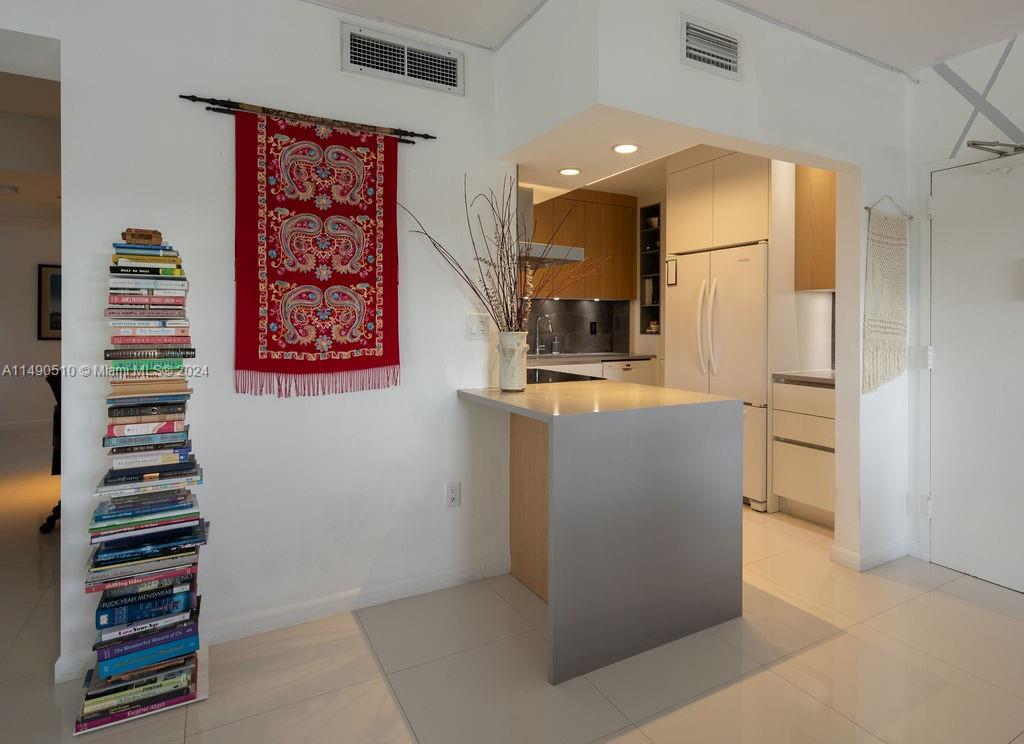 500 Bayview Drive, Unit 221 Sunny Isles Beach, FL 33160 - Photo 5 of 35 a kitchen with stainless steel appliances kitchen island granite countertop a refrigerator and a sink