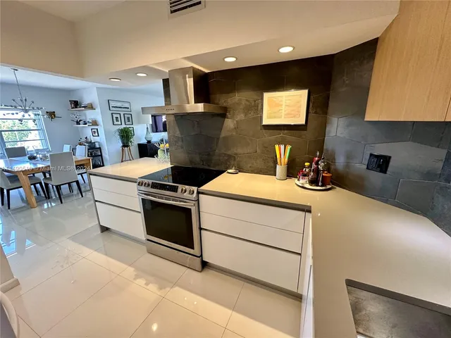 a kitchen with a stove and a flat screen tv
