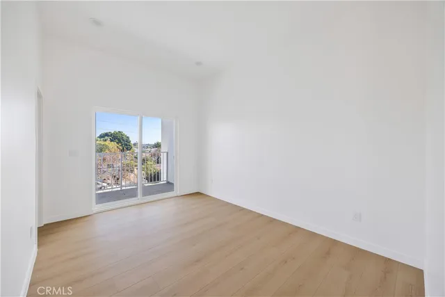 a large kitchen with granite countertop a refrigerator a stove and a sink with wooden floor