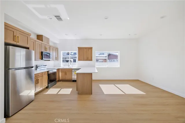 a kitchen with stainless steel appliances a refrigerator and a stove top oven