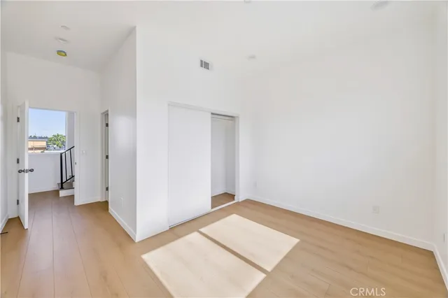 a kitchen with granite countertop stainless steel appliances a refrigerator a sink and white cabinets