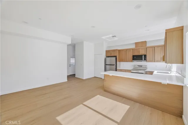 a large white kitchen with a sink and refrigerator