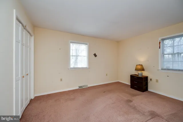 a view of an empty room with a fireplace and a window