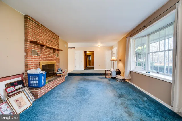 a view of an empty room with furniture and windows