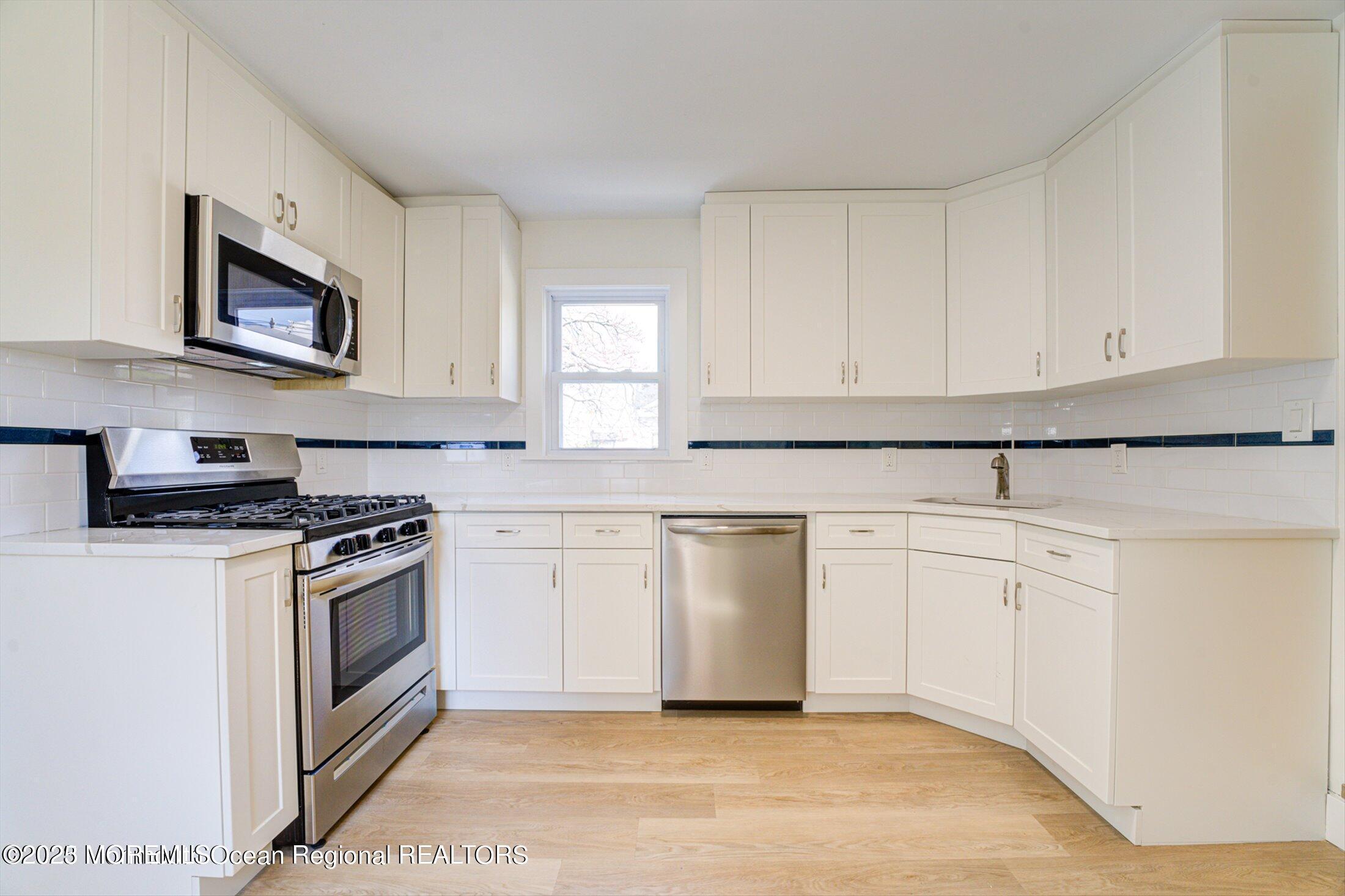 54 Main Street, Unit 2 Keyport, NJ 07735 - Photo 8 of 25 a kitchen with granite countertop white cabinets and white appliances