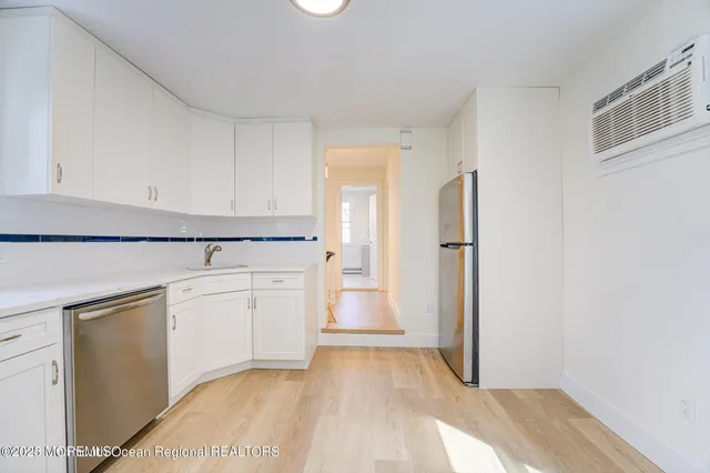 a kitchen with white cabinets and refrigerator