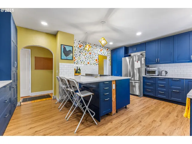 a kitchen with stainless steel appliances wooden floors and wooden cabinets