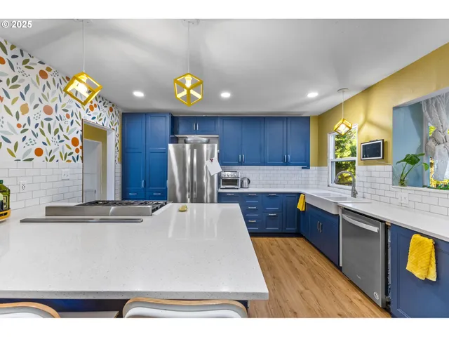 a kitchen with stainless steel appliances granite countertop a sink a stove top oven a counter space and cabinets