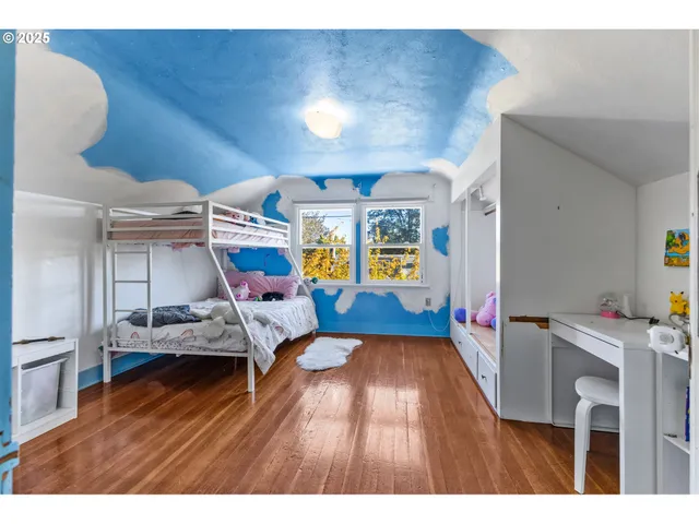 a bedroom with a bed and a wooden floor