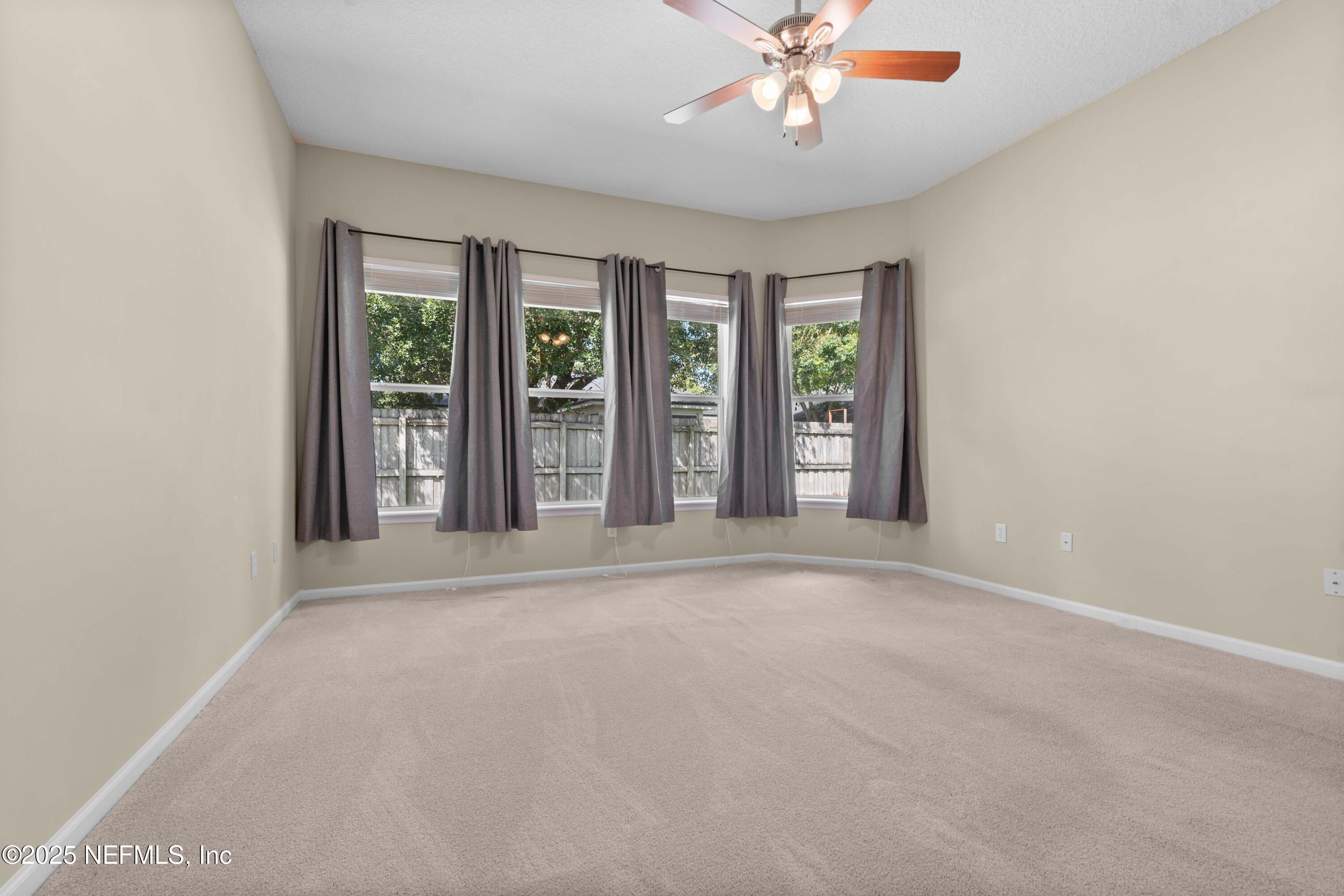11798 Blueberry Lane Macclenny, FL 32063 - Photo 14 of 30 an empty room with windows and chandelier fan