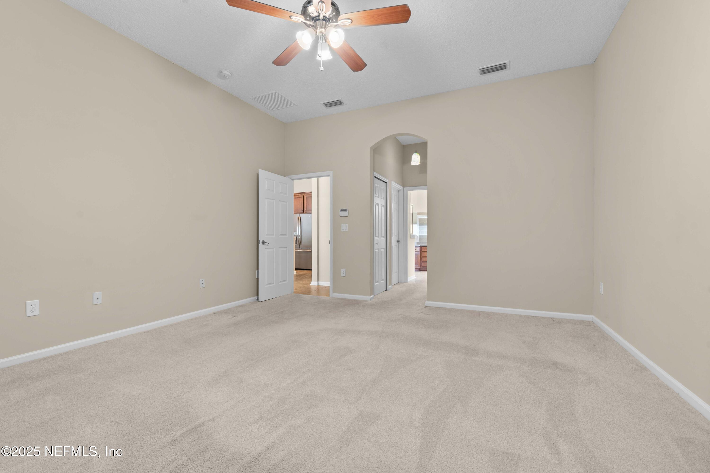 11798 Blueberry Lane Macclenny, FL 32063 - Photo 15 of 30 en empty room with windows and chandelier fan