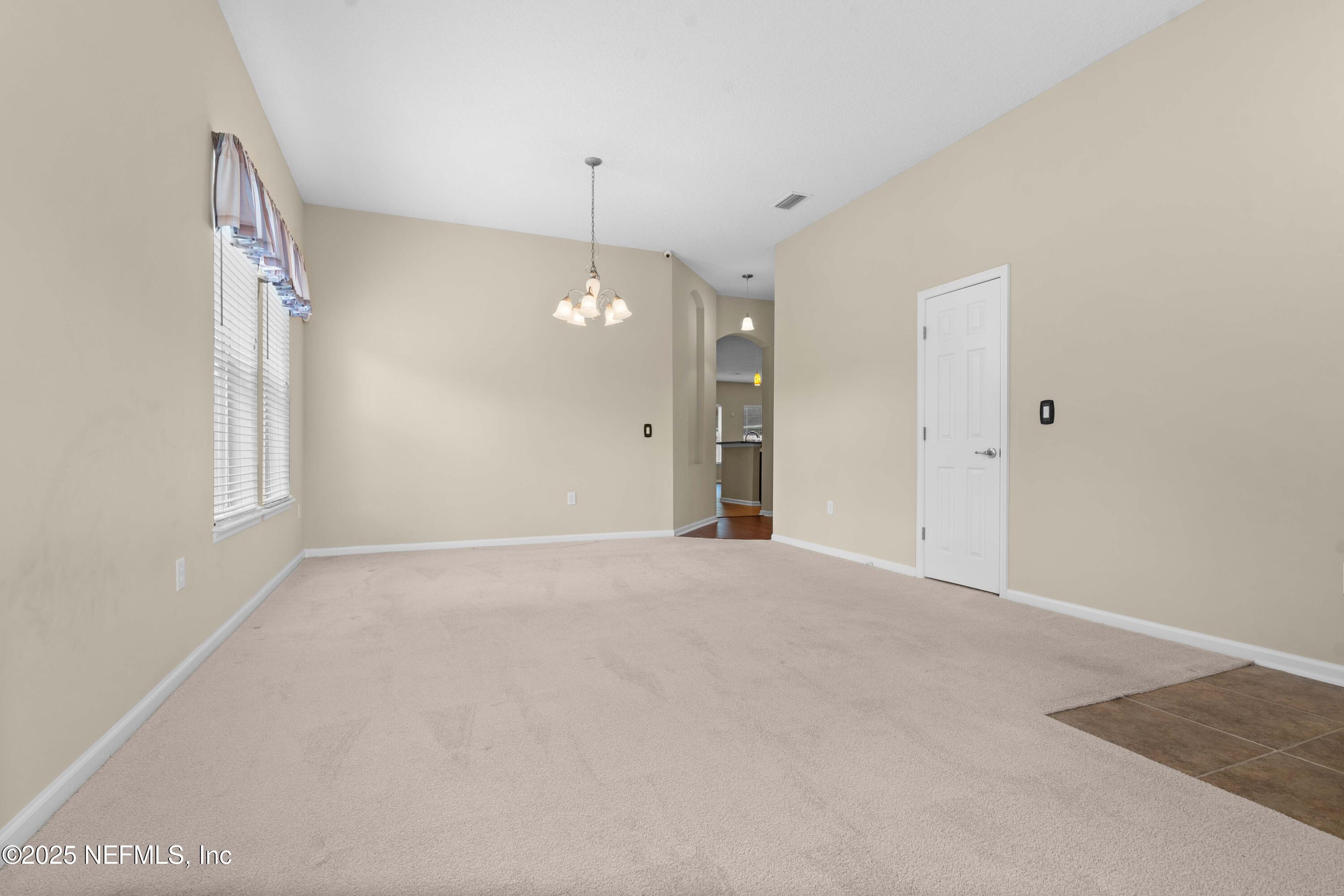 11798 Blueberry Lane Macclenny, FL 32063 - Photo 7 of 30 an empty room with chandelier fan and windows