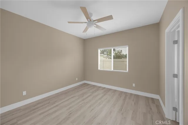a view of a big room with wooden floor and a ceiling fan