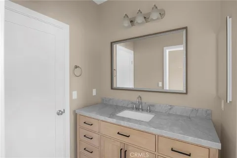a bathroom with a granite countertop sink and a mirror